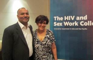 Indoor photo of Pradeep Kakkatil (UNAIDS) and Tracey Tully (APNSW) against backdrop of large banner of the report cover